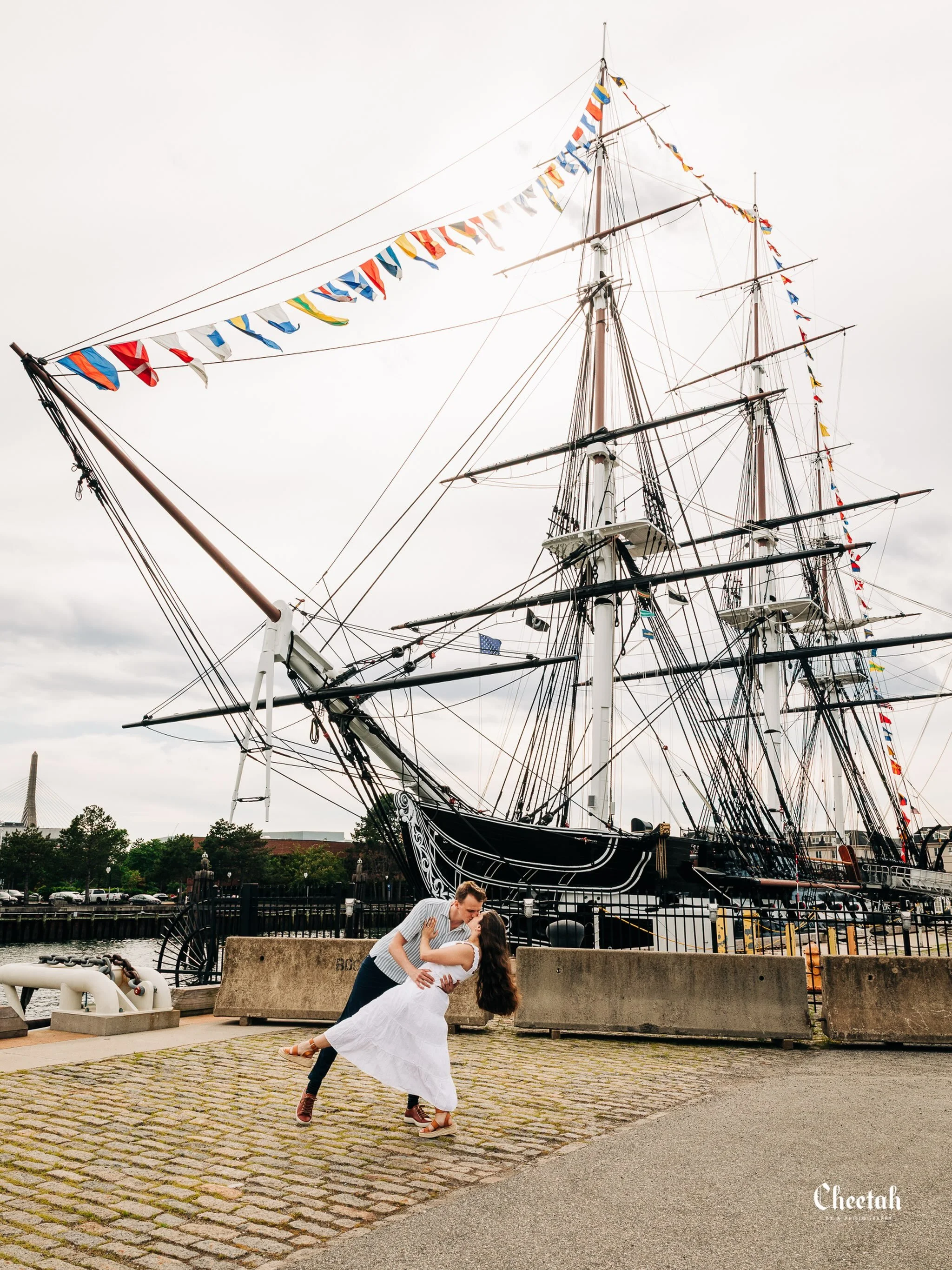 Love anchored in history. ⚓️❤️

Some moments deserve a backdrop as timeless as the story being written. Beneath the towering masts and centuries of maritime history, these two made the harbor disappear&mdash;seeing only each other. Boston never disap