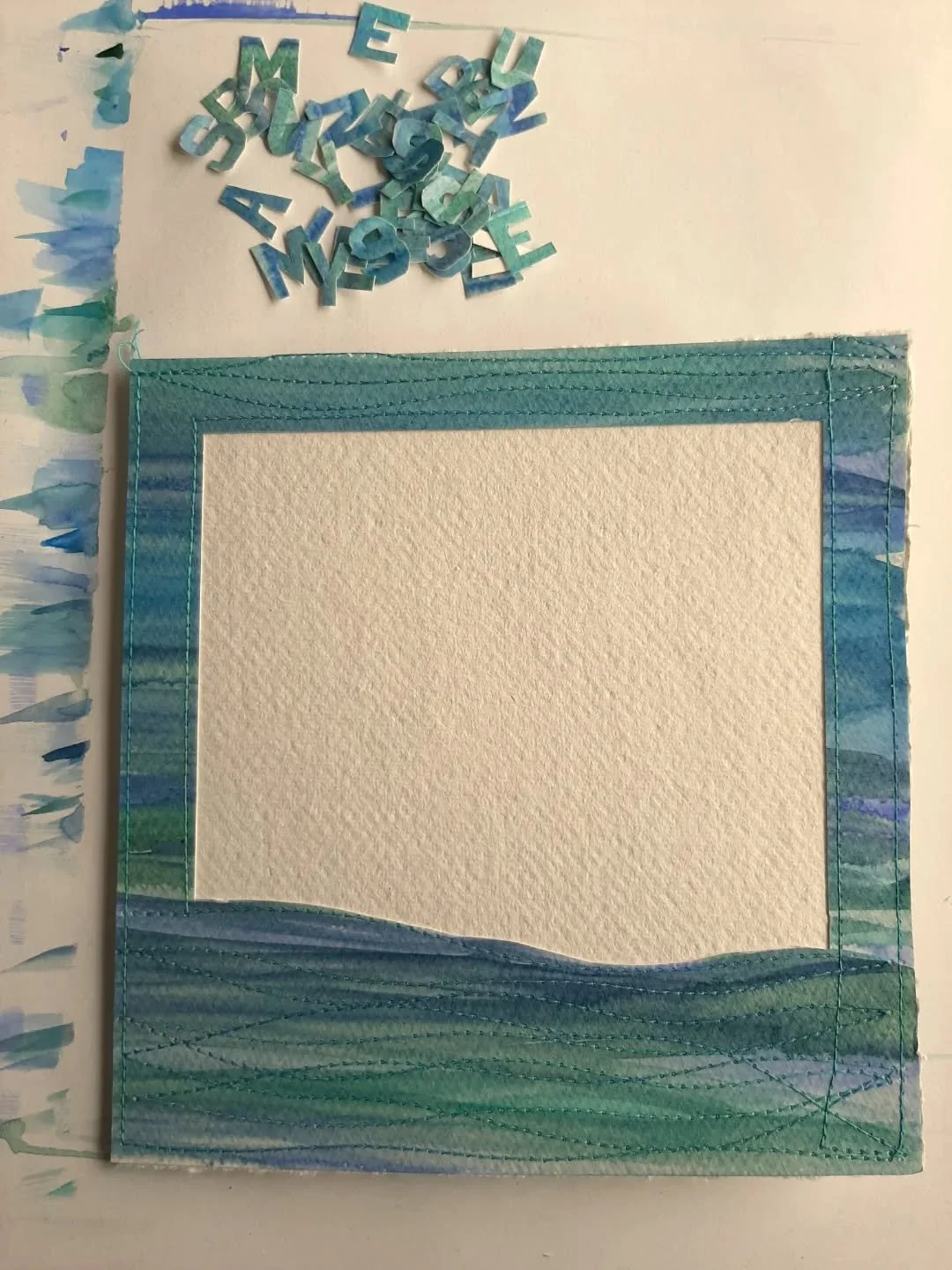A #HandmadeCard in progress for a special event. 
I wonder if you can guess what the wording will say? 🤔😁

#TheCreativeSpace #MindfulnessAndCreativity 
Mixed media. Sewing with paper. 
Sewing on paper. 
Watercolour paints. Seascape. 
Wedding card. 