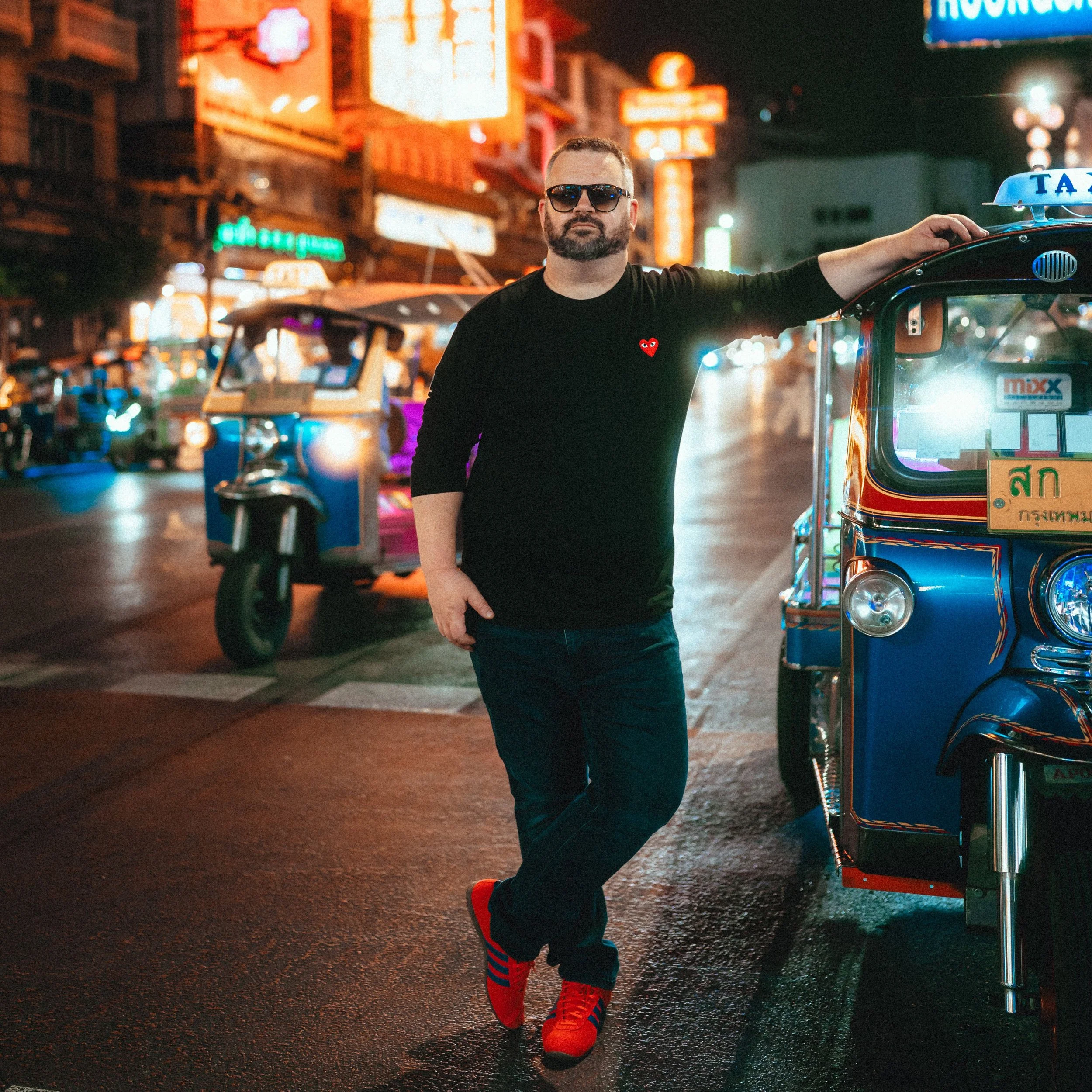 A phot of Brendan le Grange, leaning against a tuk tuk in Bangkok's China Town of fintech and foresttech