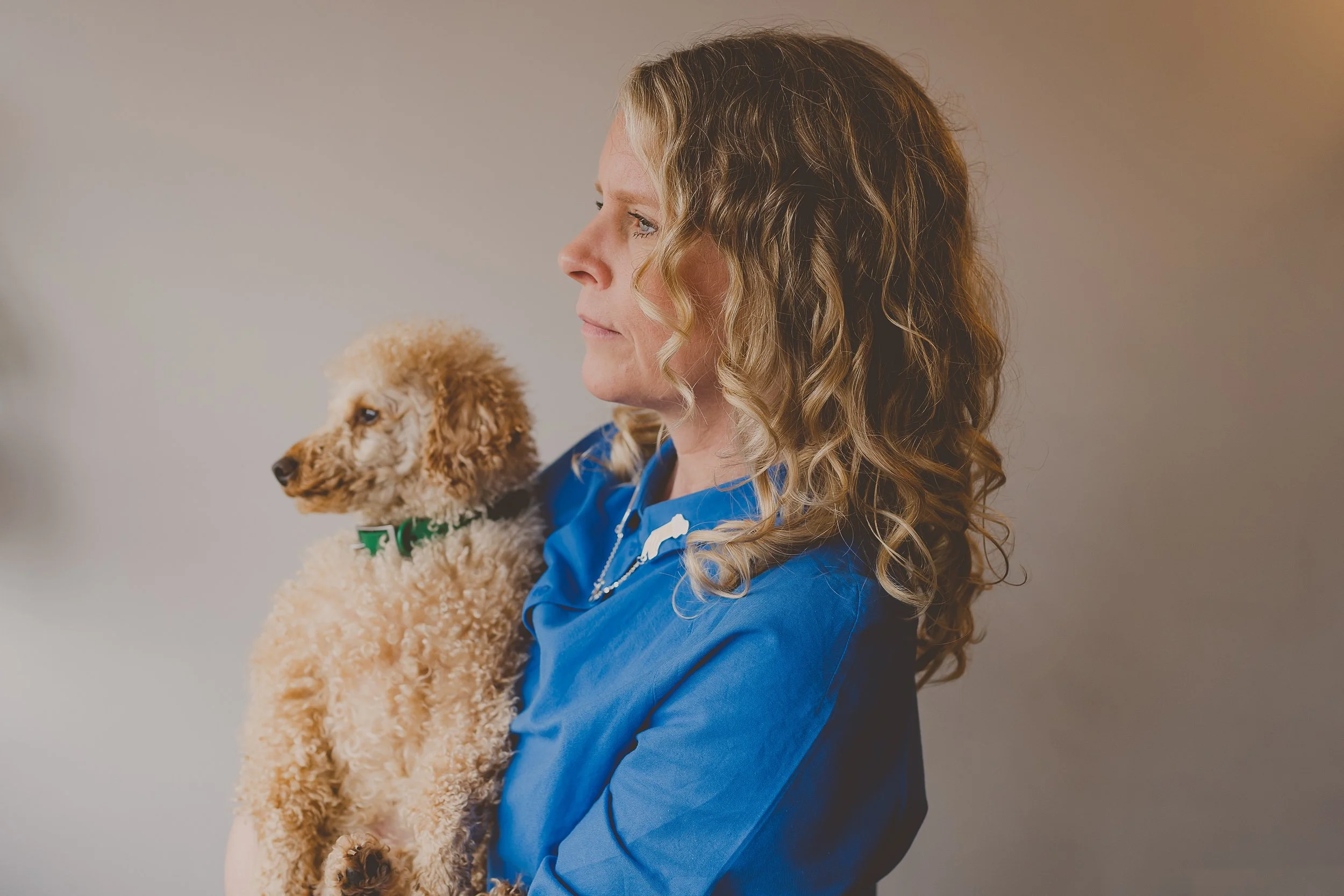 Lindsey, curly hair specialist, with her natural curls and her dog