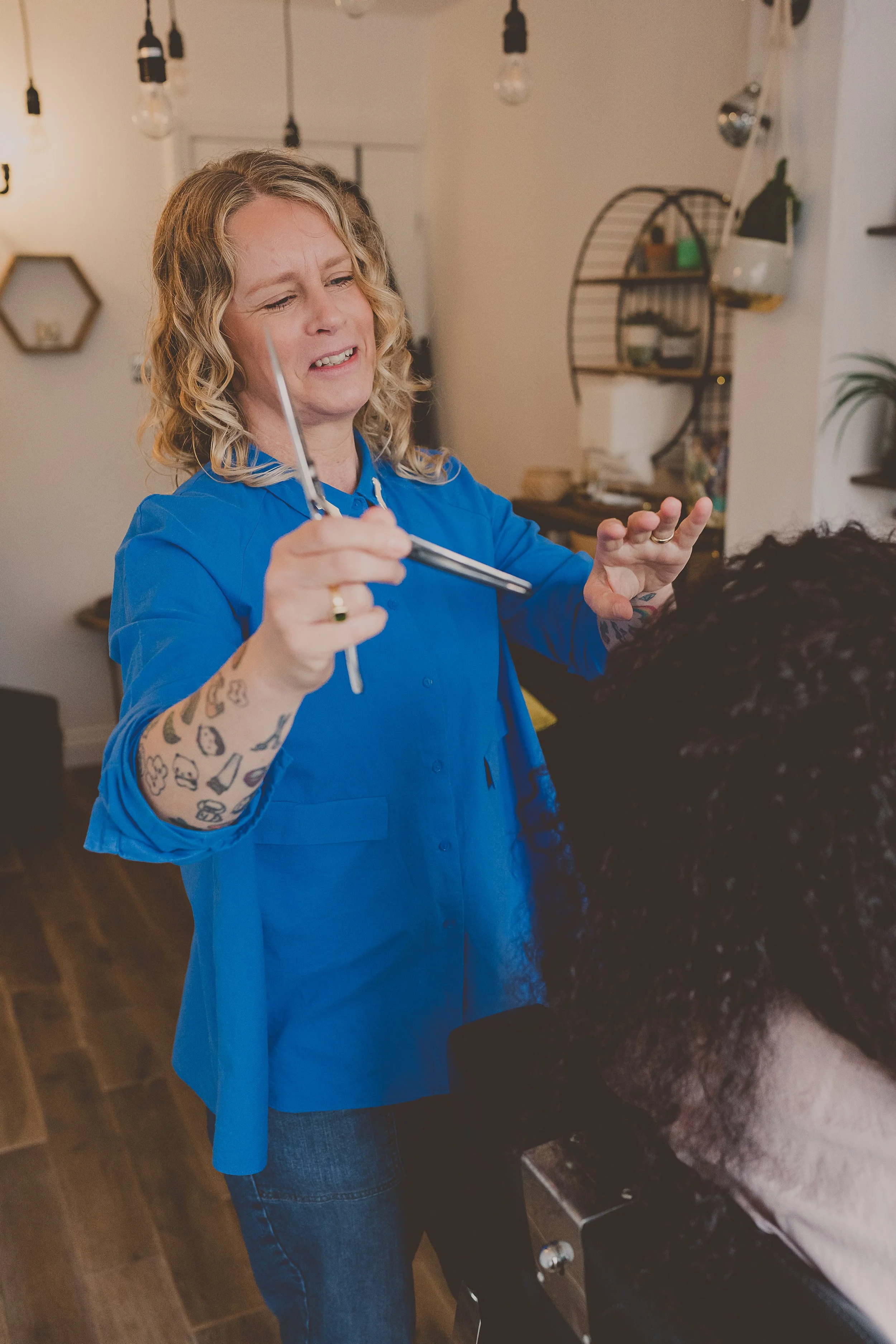 Lindsey dry cutting a client's curls in her Rugeley studio