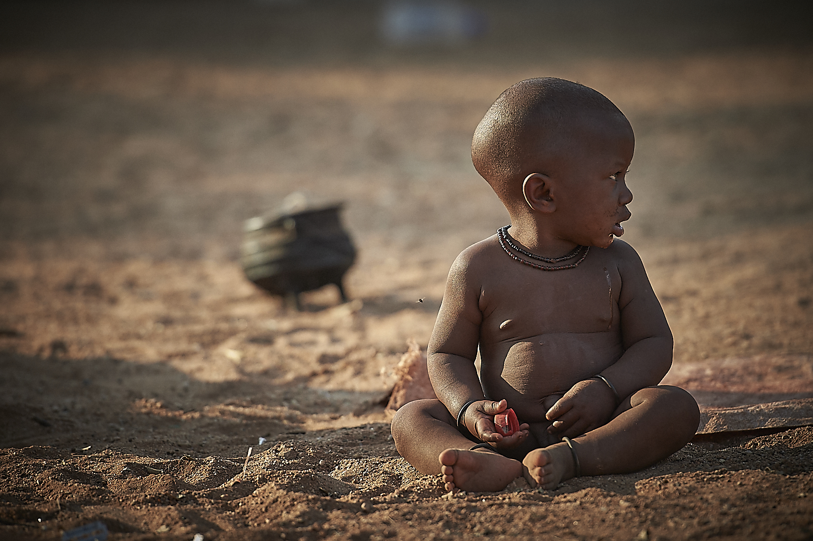 very young himba children are left, pretty much alone, throughout the day, to care for themselves. women have their hands full with the daily household and village chores.