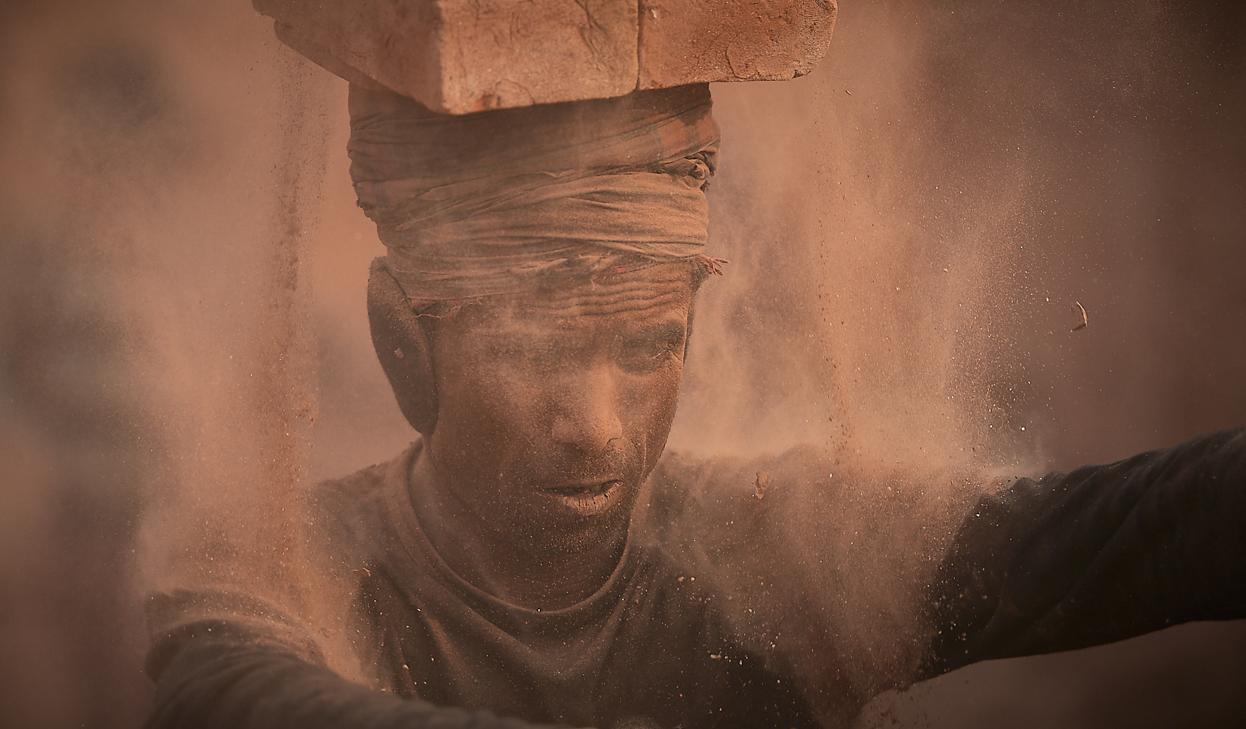 worker removing baked bricks from the kiln