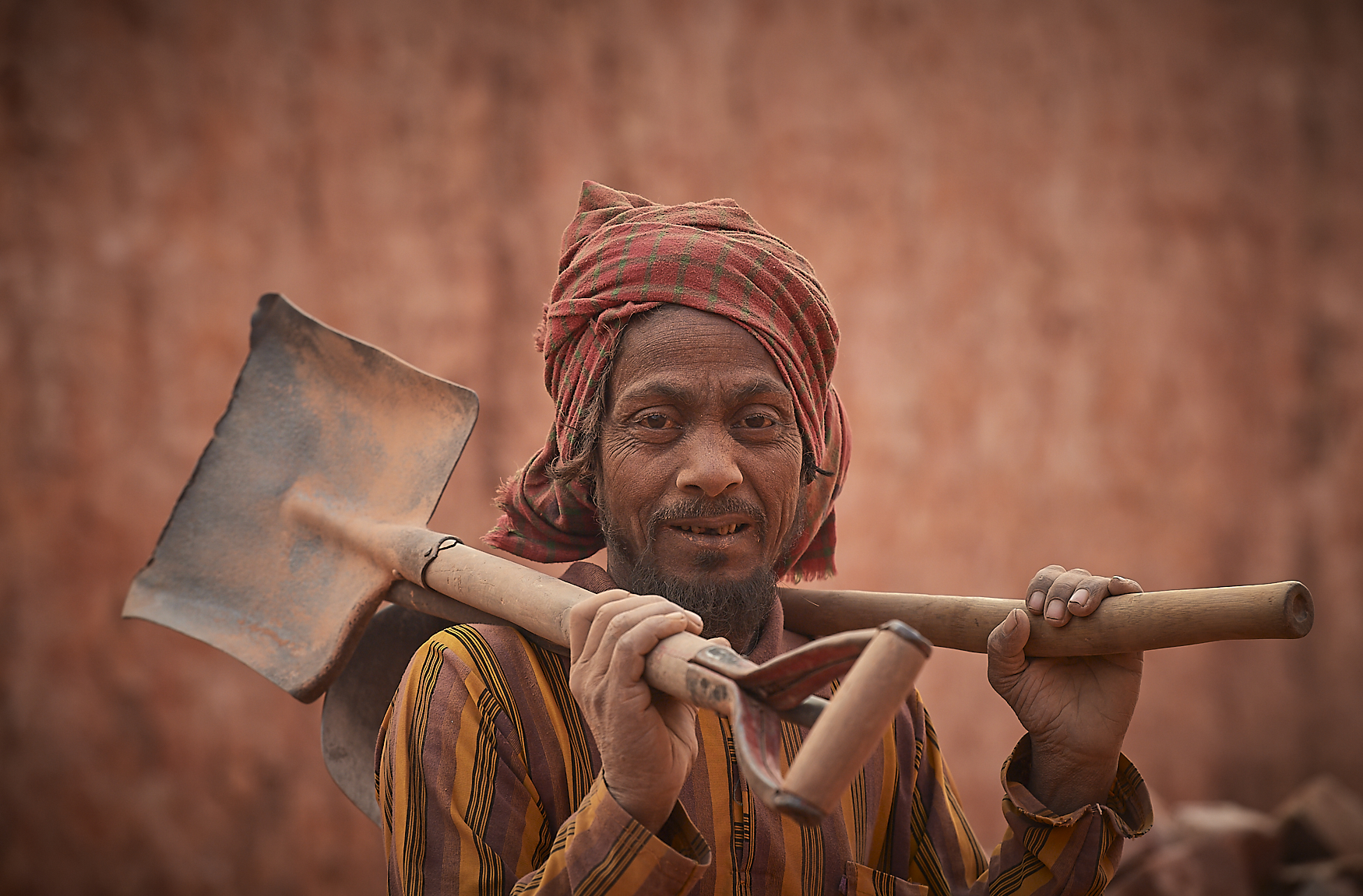 worker collecting sand to cover bricks for baking