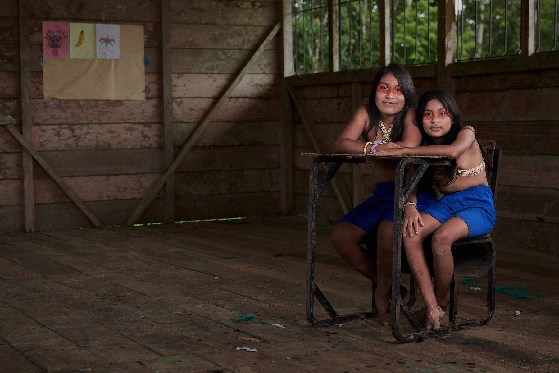 Damaris and Naeli sharing a desk in the old classroom. Thanks to an NGO, they now have new classroom buildings