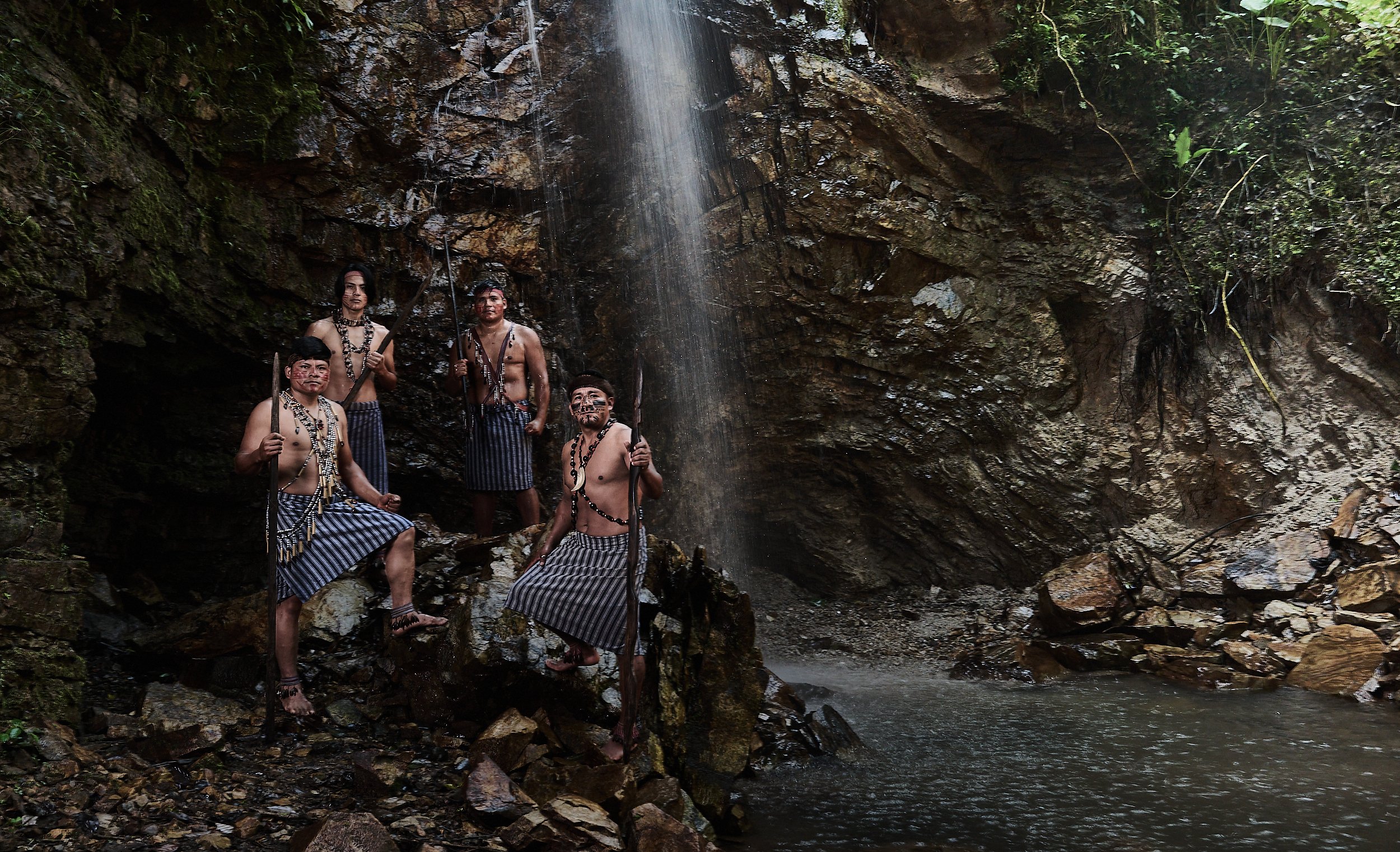 Shuar warriors in traditional attire at the Kinthia Panti waterfall