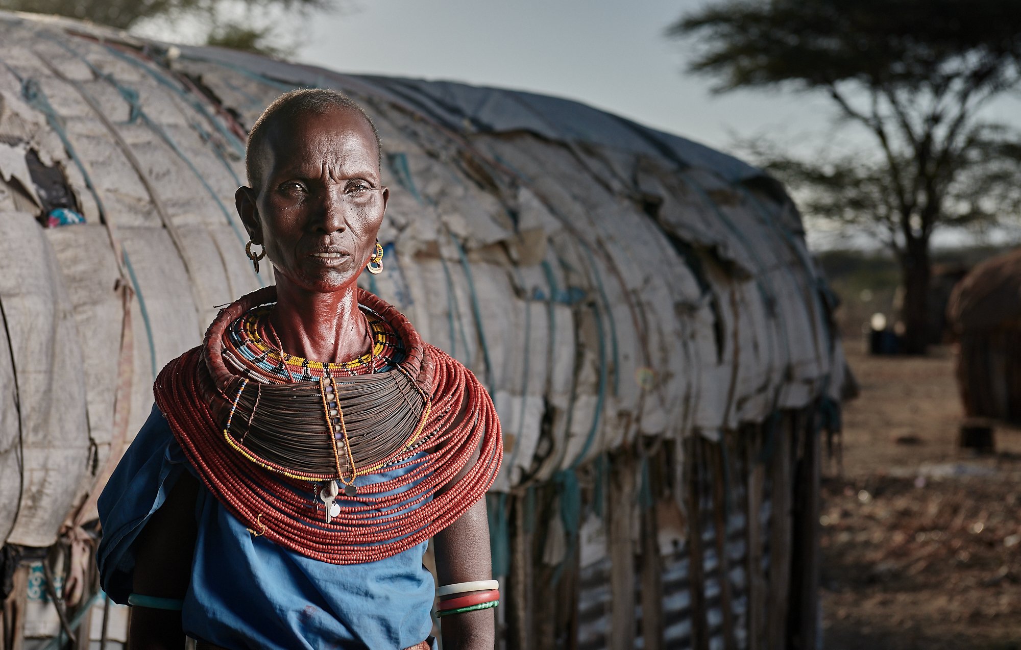 Senior Samburu wife in front of traditional hut