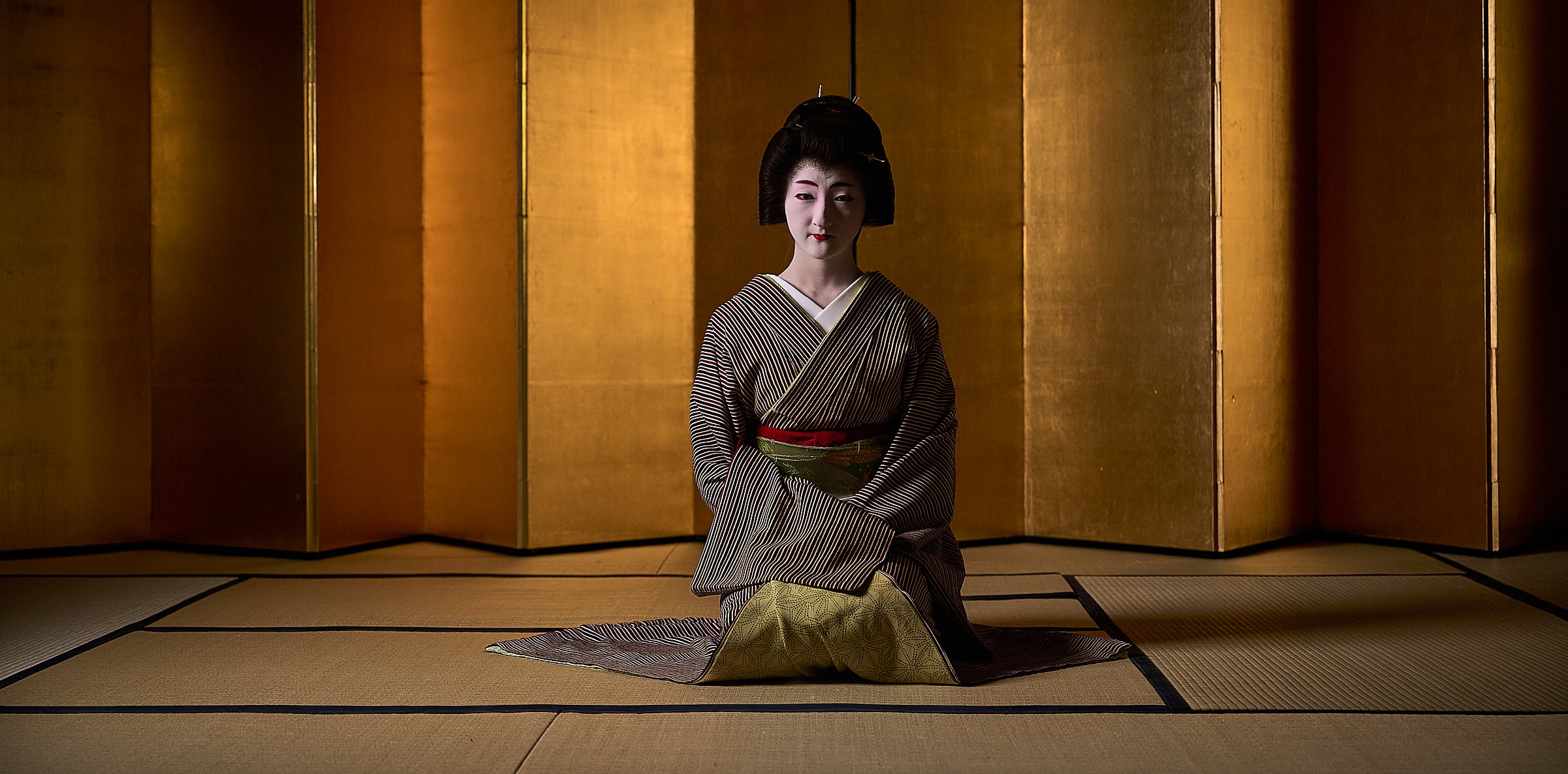 A geiko (a Kyoto geisha) shot in front of a 150yr old gold leaf shoji screen