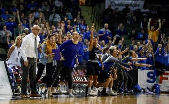 Student coach Jill Ricke, SFLS class of 2012, cheers the Dakota Wesleyan University Tigers on from the sidelines during the 2018 NAIA Division II tournament.
