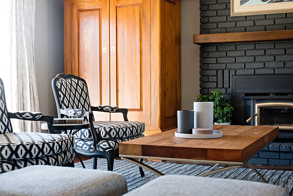 This living room design by Four Blocks South interior design, blends hand-crafted locally-made furniture with vibrant textured custom upholstered chairs and ottomans for plenty of seating.