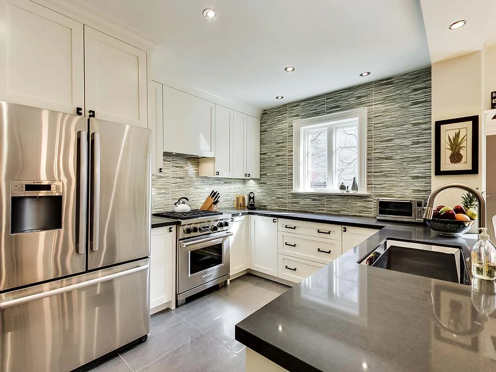 Kitchen area with stainless steel appliances and marble countertops