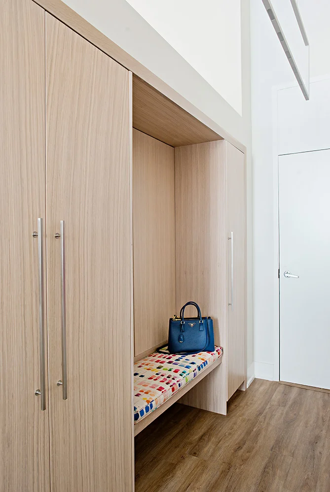 Custom white oak cabinetry and bench provide a sophisticated entry with lots of hidden storage.