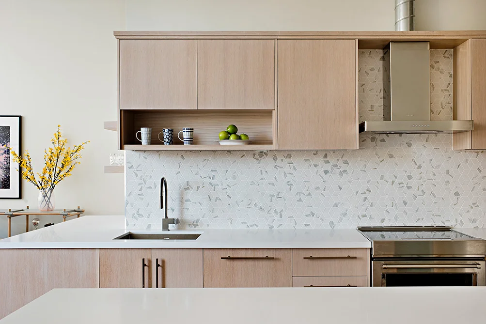 Mosaic tile cararra marble kitchen backsplash with white oak custom cabinets and white quartz countertops.