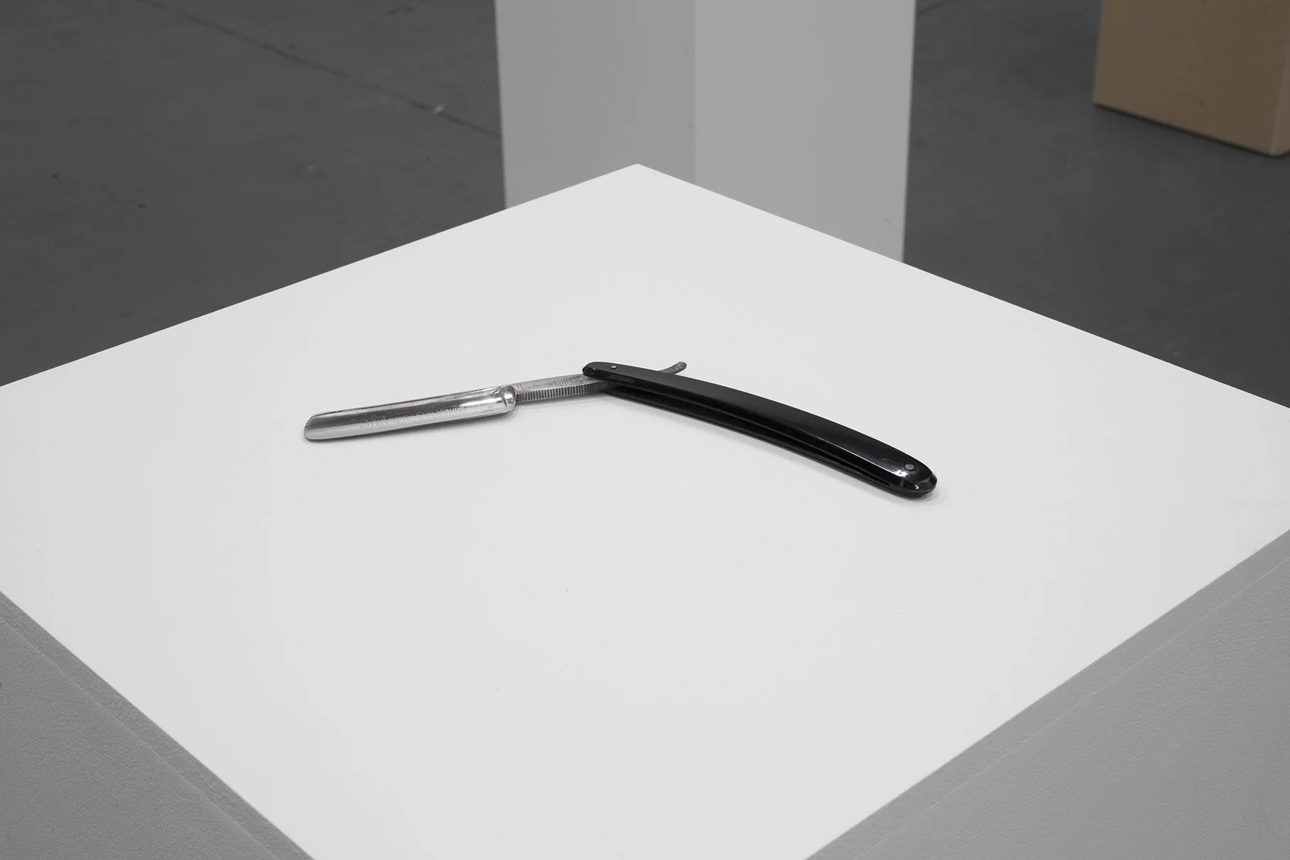 Roddy Buchanan Unexpressed Open cut-throat razor 1 x 19 x 15cm Iʼve wanted to make this since 2007. The dateʼs stuck in my head because I remember having a conversation with this man at the opening of my exhibition ʻFrom a City of One Millionʼ at La Criee in Rennes. We talked about the risks you can take in a museum and I said Iʼd always wanted to place a cut-throat razor on a plinth in a gallery open to the public. The next day he came into the exhibition with his grandfatherʼs open-razor and said ʻIʼve wondered what to do with this for years - Here, you should have itʼ. Iʼve always had a visceral response when thinking about open razors, perhaps it goes back to seeing that photograph of George Johnston defending himself against Brian Stewart in the Express back in the 70ʼs. The young guy slashing the old guy in Glasgow city centre. This guilty object has sat in my studio for years. To be true to the intention of the work, as it was discussed all those years ago, the object has to lay unsecured and open to the audience on top of the plinth.