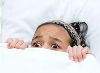 Woman in fear under blankets