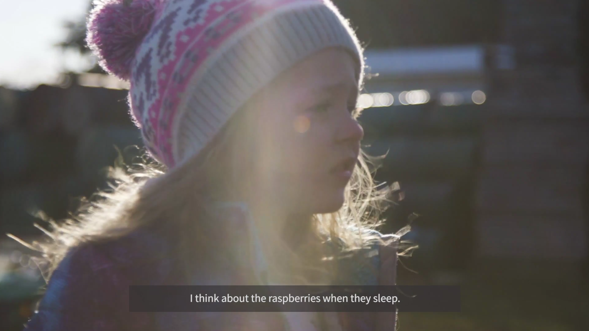 child from Wild Hive saying “I think about the raspberries when they sleep,” wearing winter hat