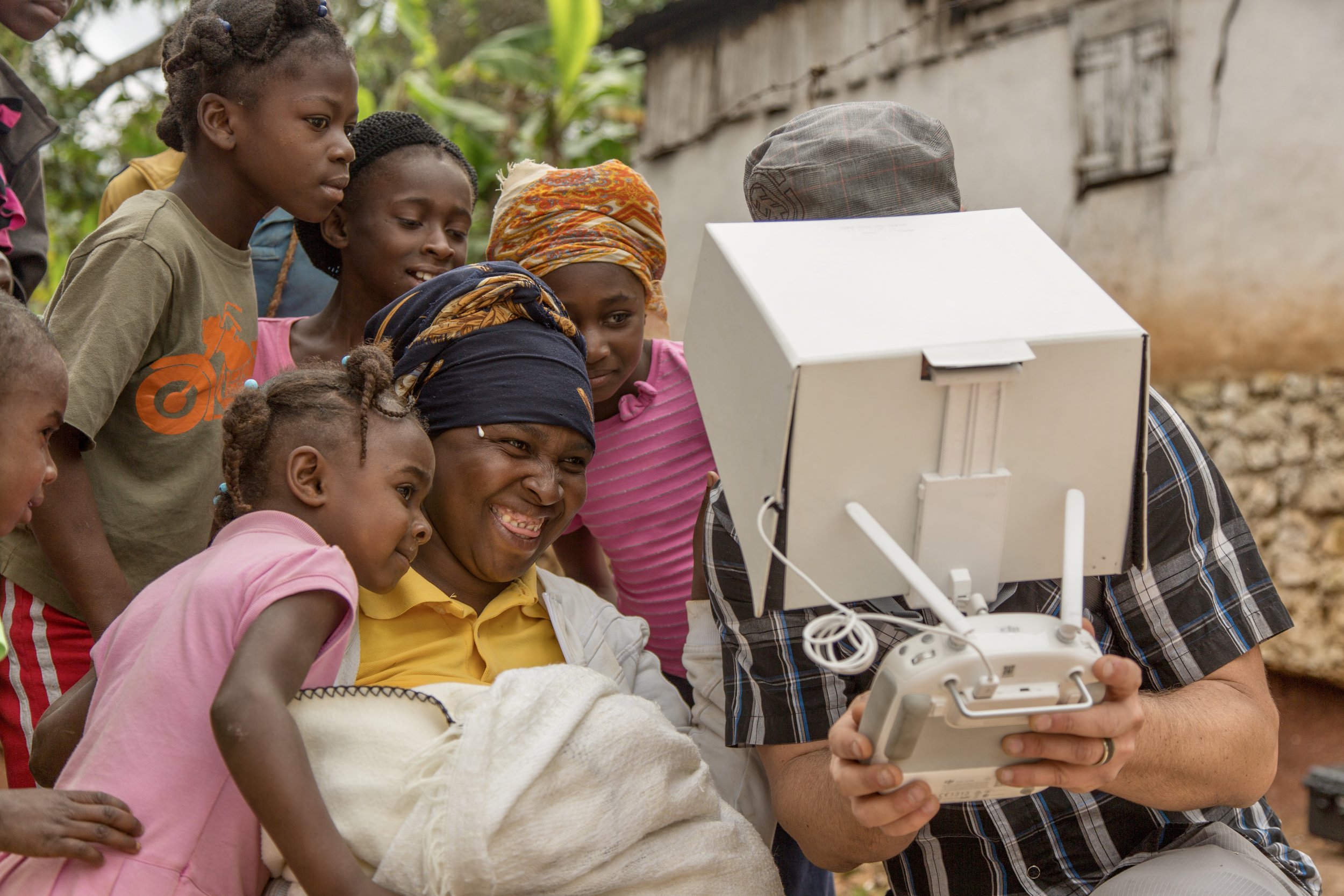 Soulcraft Allstar Creative Director + drone pilot in Haiti showing a family the view.
