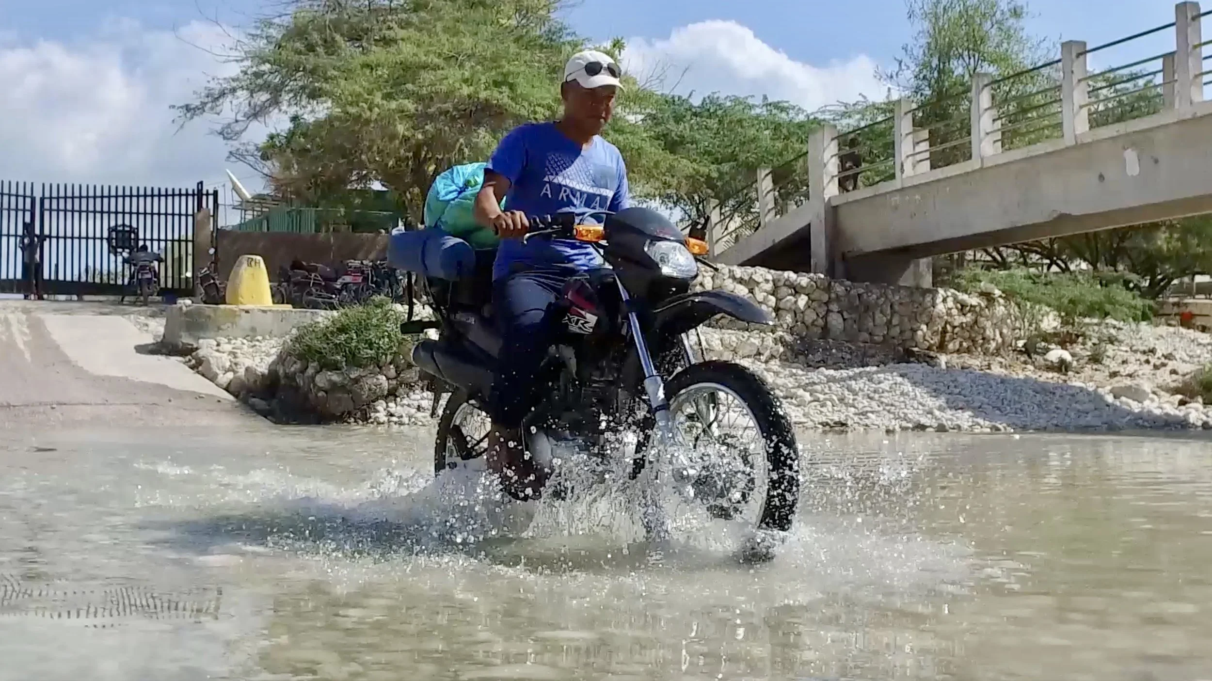 Dominican Republic Field Biologist and Artist Jose Luis rides his motorcycle across the Haitian border to help a neighboring village.
