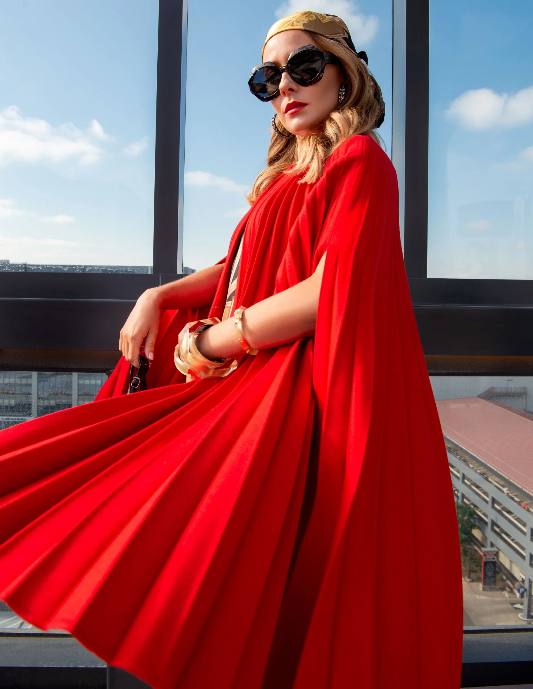 Dress: Burberry, Cape: Valentino, Sunglasses: Dior, Sandals: Balenciaga, Earrings: Oscar de la Renta, Bracelets: Alexis Bitar, Scarf: Burberry