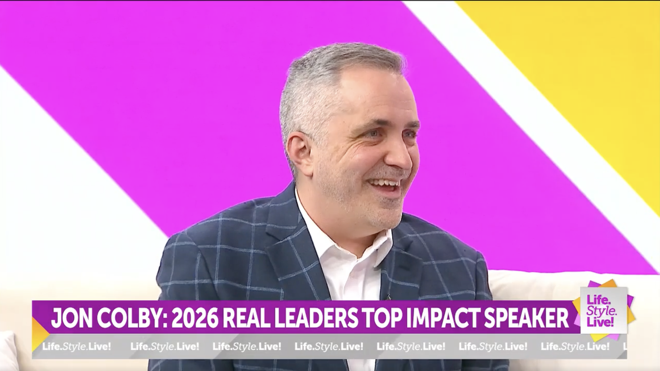 Jon Colby smiling during a television interview on WISH-TV's Life.Style.Live!, with an on-screen graphic reading "Jon Colby: 2026 Real Leaders Top Impact Speaker.