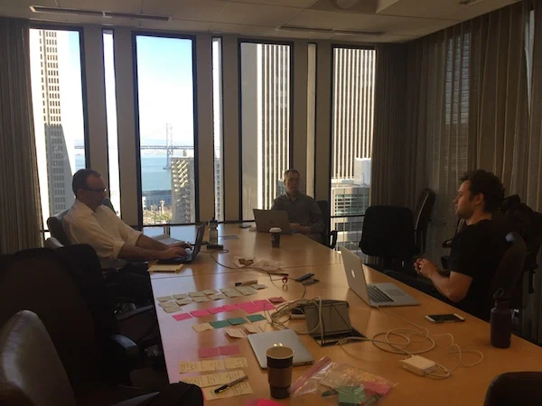 Photo of team collaboration around a board room table.