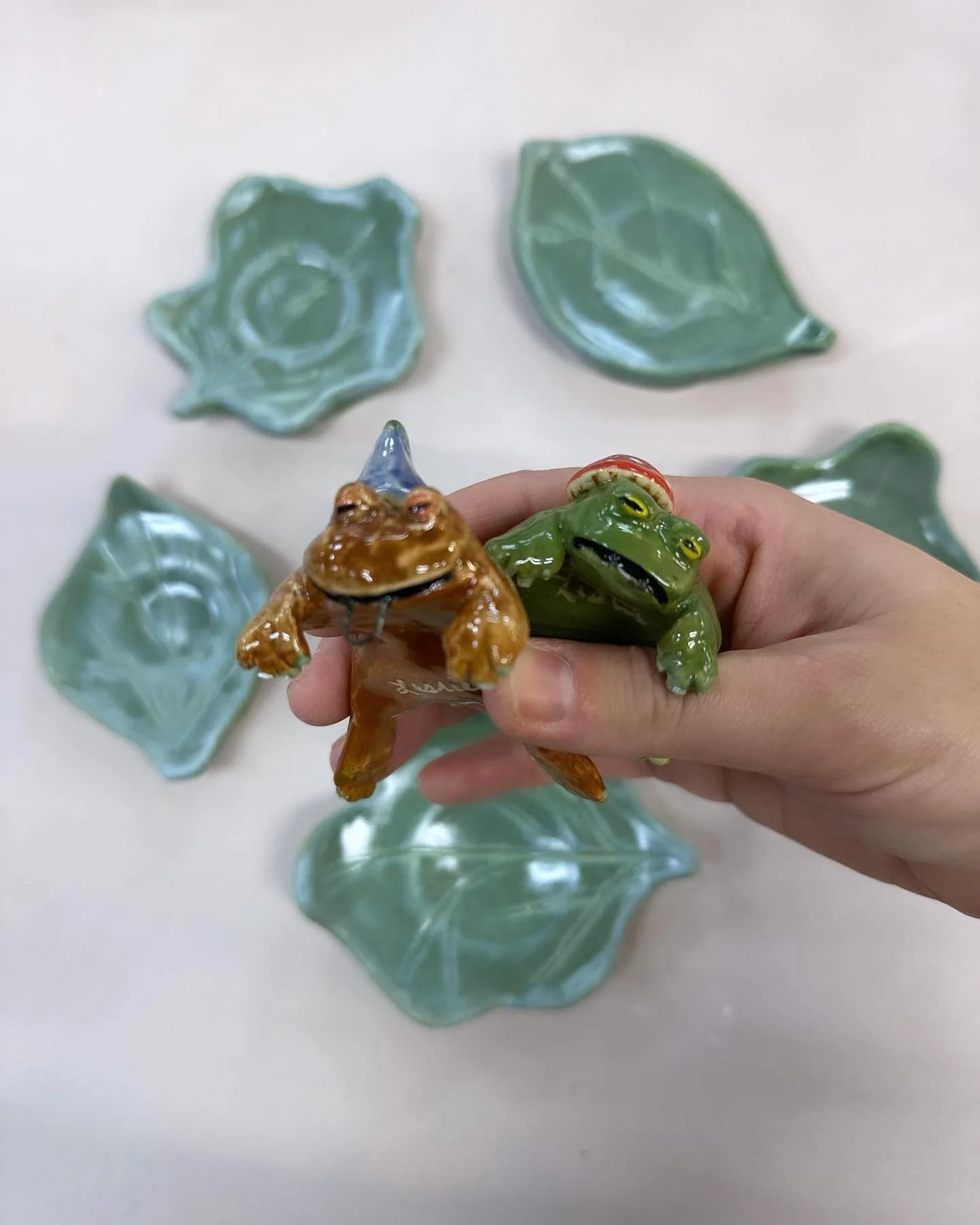   Leslie Mueller    Untitled   Ceramic   Description:  I modeled these tea buddies after a frog hanging onto a branch.   Artist background:  Leslie Mueller is a multimedia visual artist, art instructor, and Registered Art Therapist. She enjoys creati