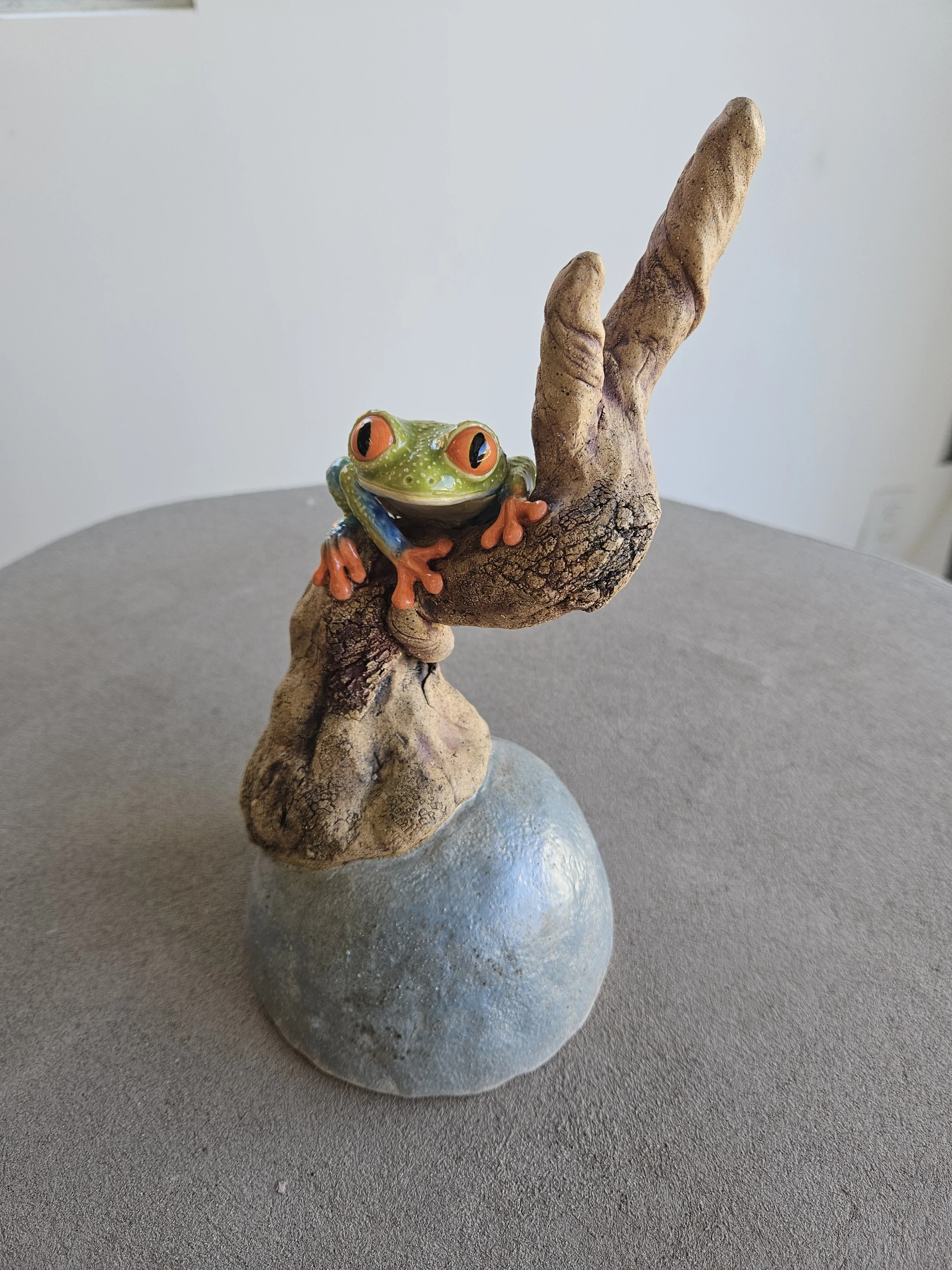   Sookyeun lim    Tree frog on a tree , 2026  Ceramics   Description:  The sculpture is inspired from the striking, vibrant colors of the red eyed tree drog   Artist background:  Instagram @sky_pottery 