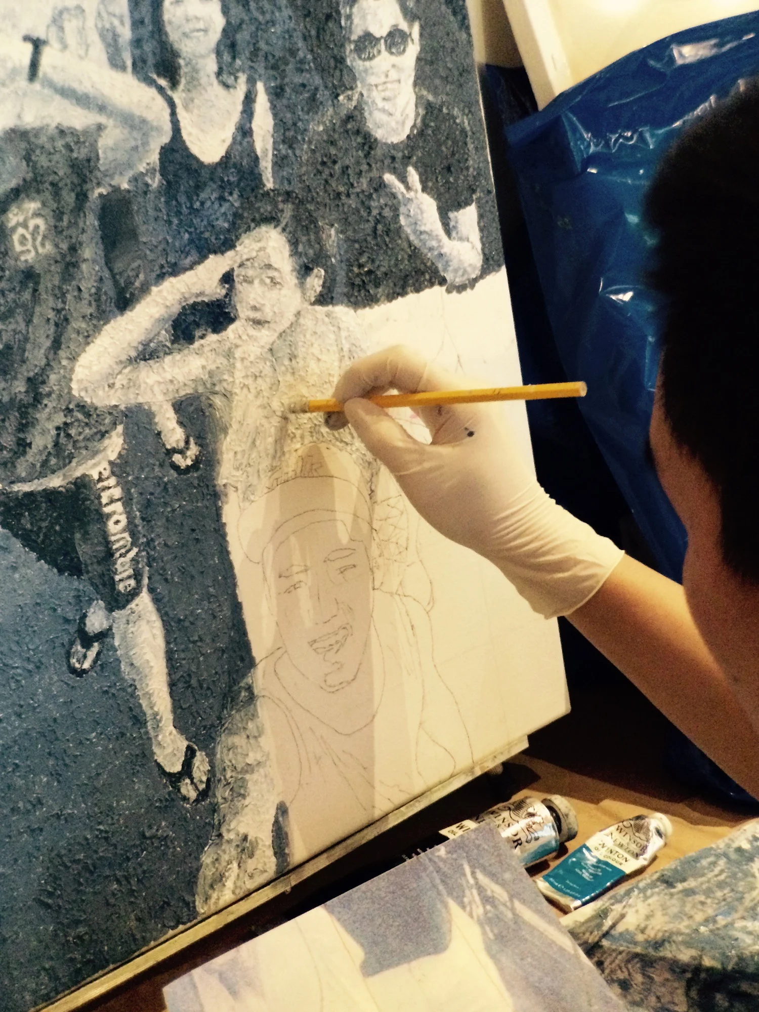 Student painting group of people in lower right corner of canvas