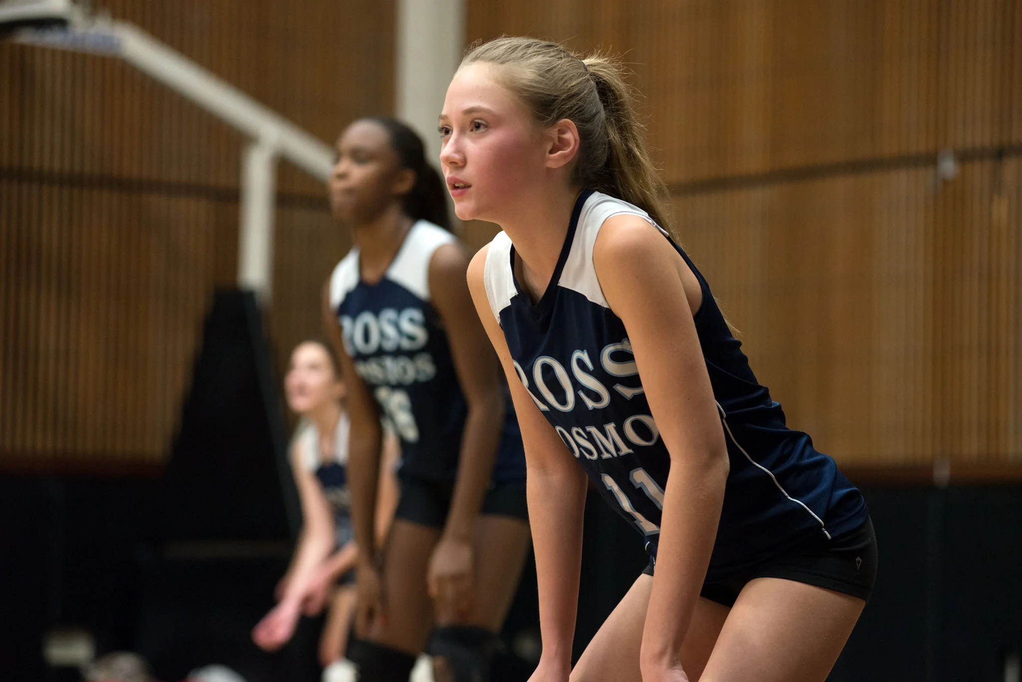 Ross High School Girl’s Volleyball team in athletic uniforms, ready to begin play.