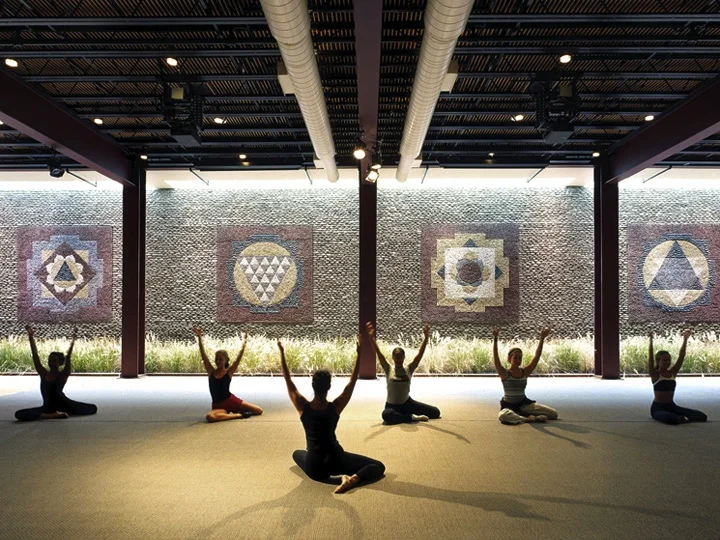 Ross Upper School students in participating in a yoga class in seated poses.