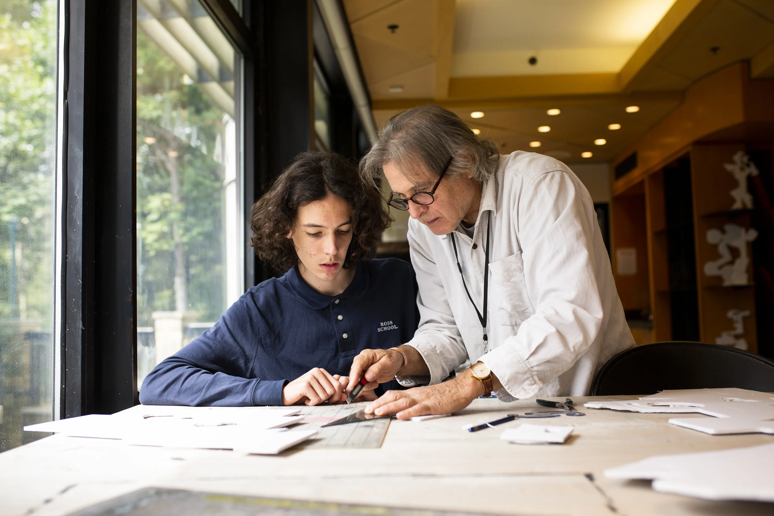 Well-known sculptor and Ross School art teacher Ned Smyth works with an upper school art student.