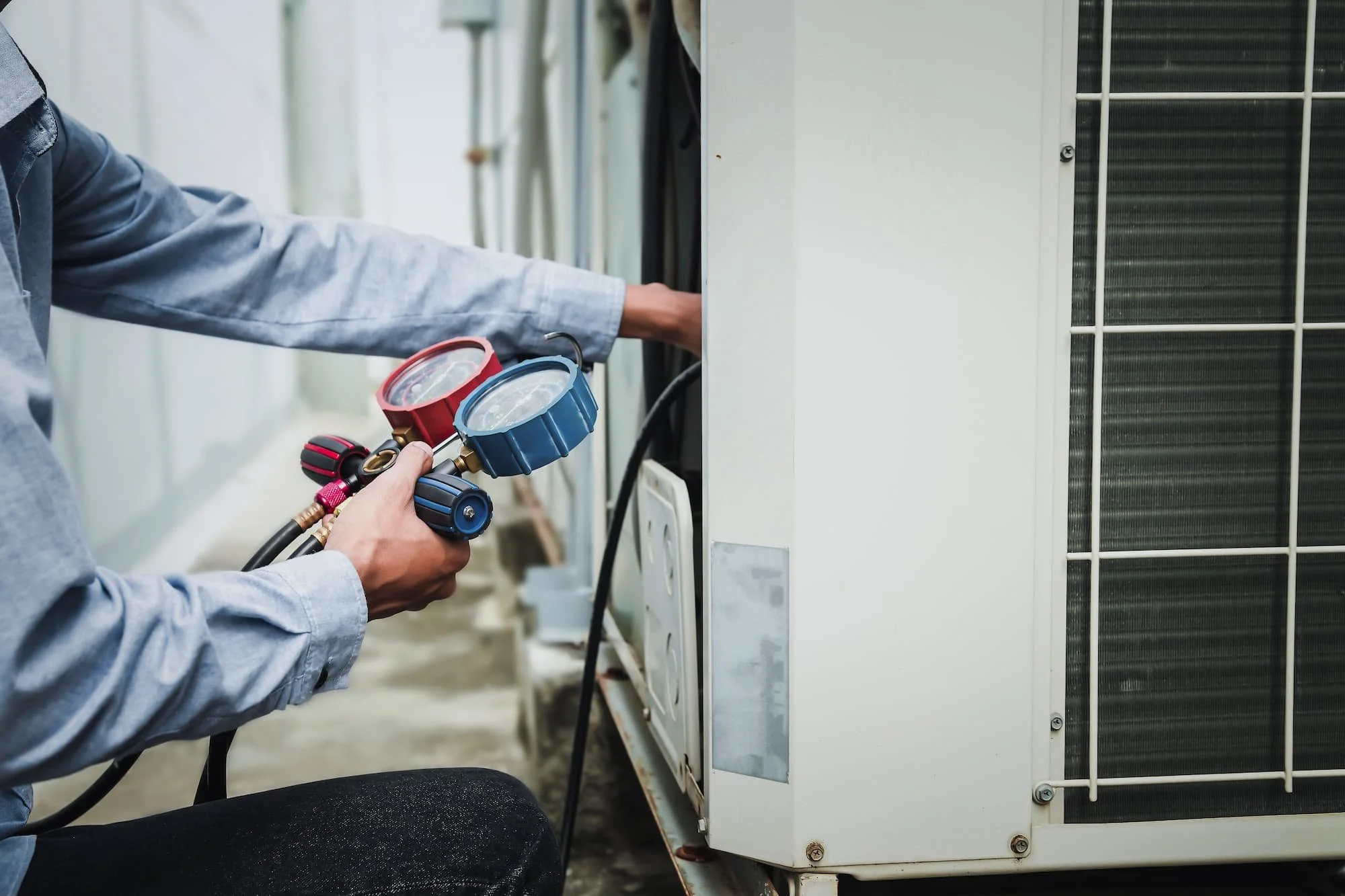Technician performing HVAC maintenance and repair on an outdoor unit in Concord New Hampshire