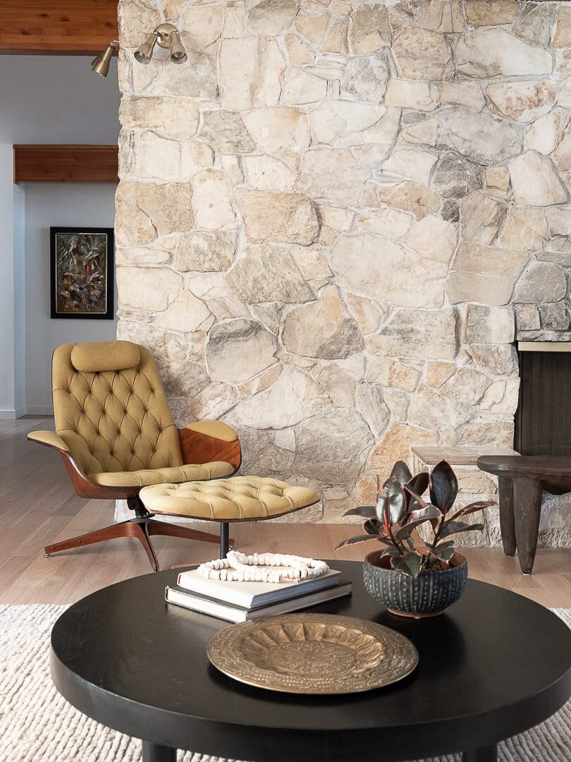 eames inspired chair against stone wall