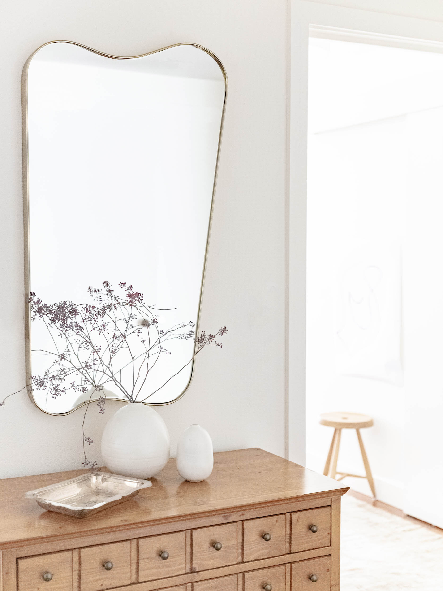modern mirror above antique dresser