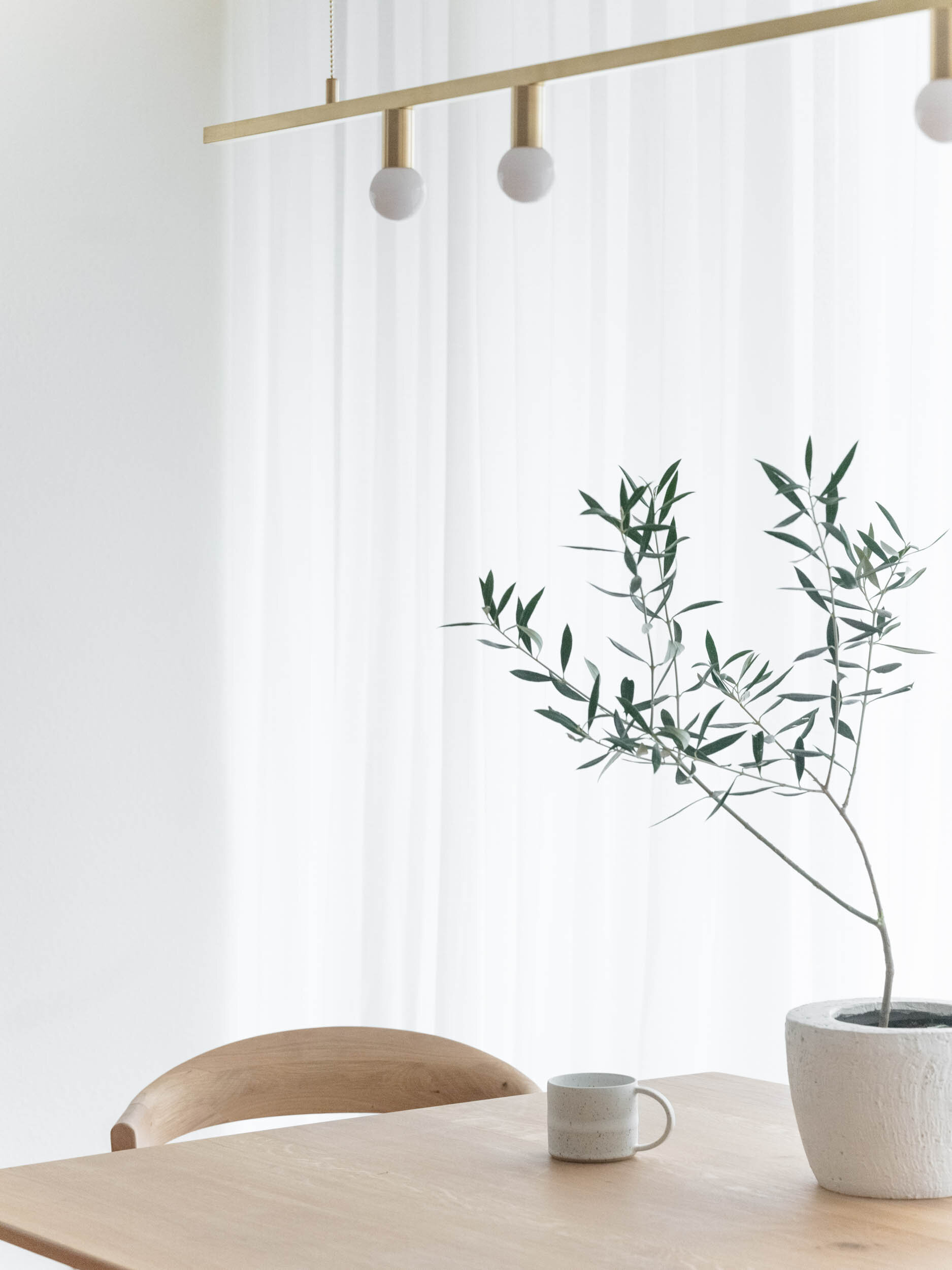 gold lighting in dining room with light wood table