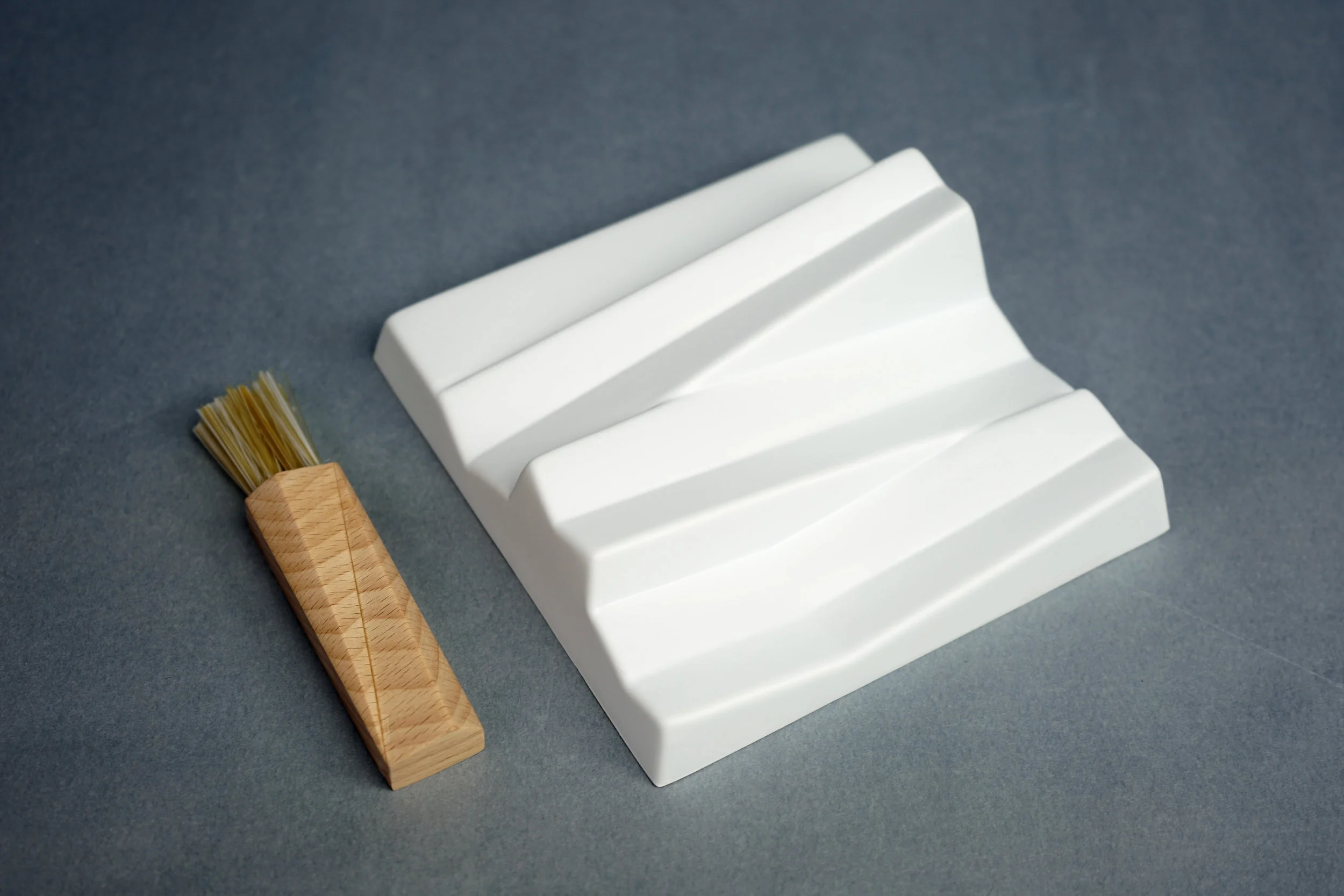  Three sloping surfaces to accommodate pens, pencils, and other longer items. Flat space on one end for the brush to sit.  