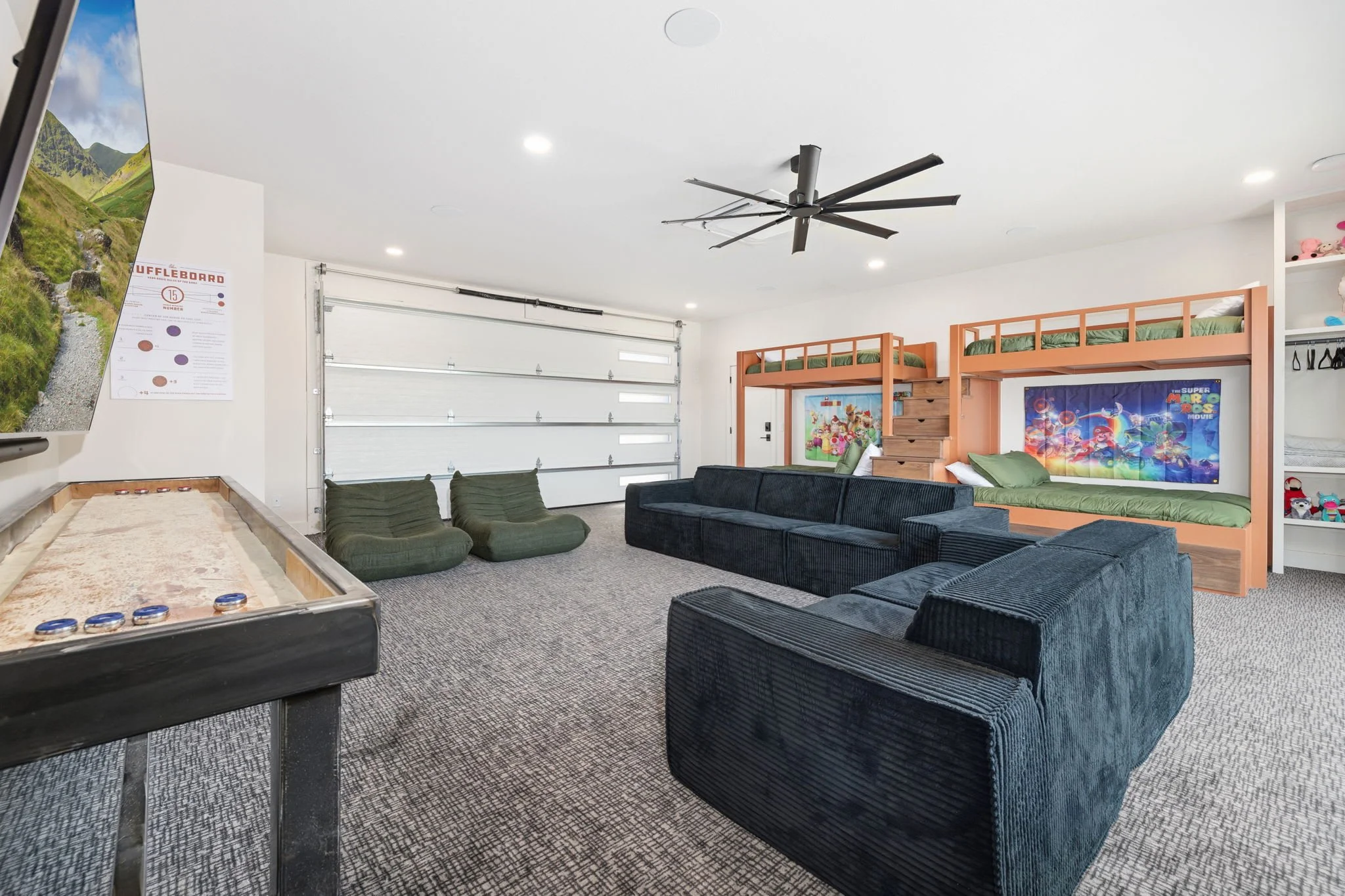 In the game room, you'll find another huge smart TV, cozy seating, and a shuffleboard table!