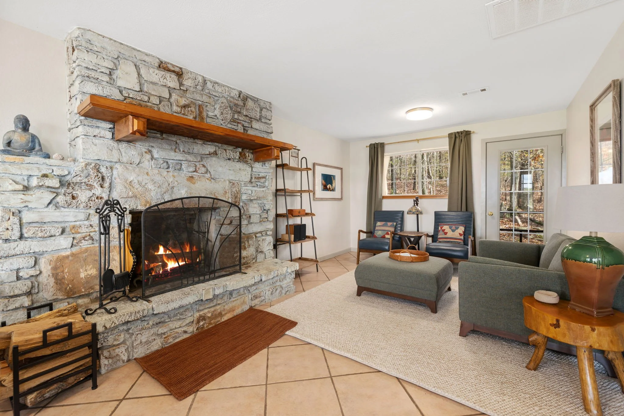 The living room has seating and a cozy natural wood burning fireplace.