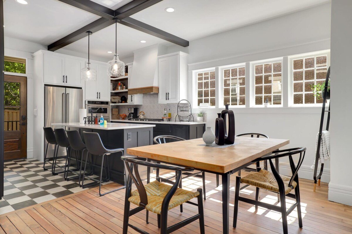 A four-top dining table is situated between the living and main kitchen.