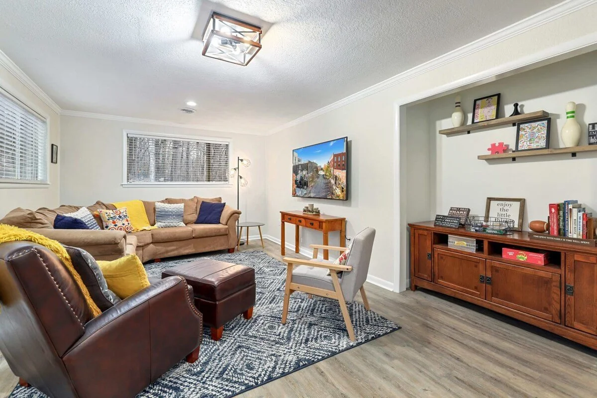 Here, you'll find a large sectional, two lounge chairs, a 65-inch Roku TV.