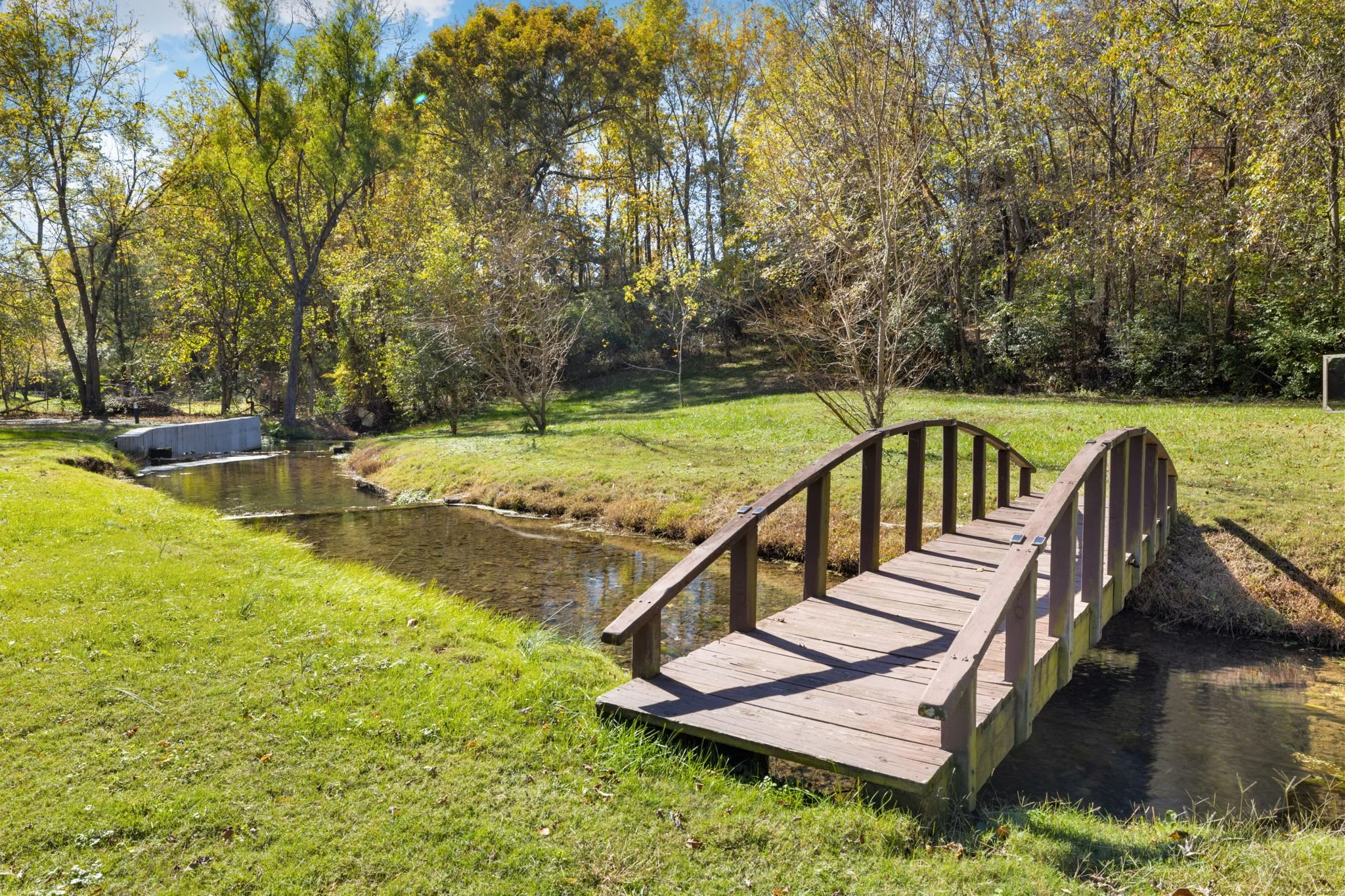 The large back yard and bridge over the stream offer a picturesque experience.
