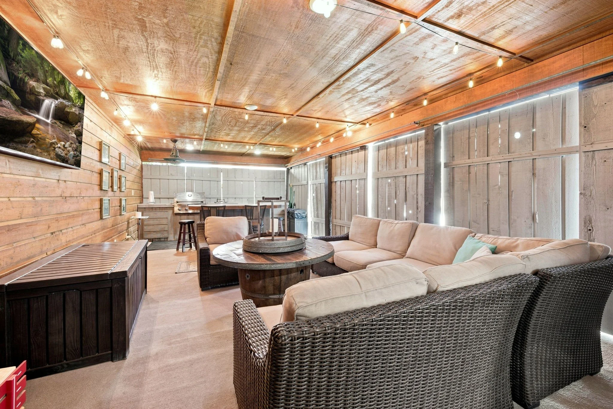 The pool house lounge is complete with a cozy sectional and TV.