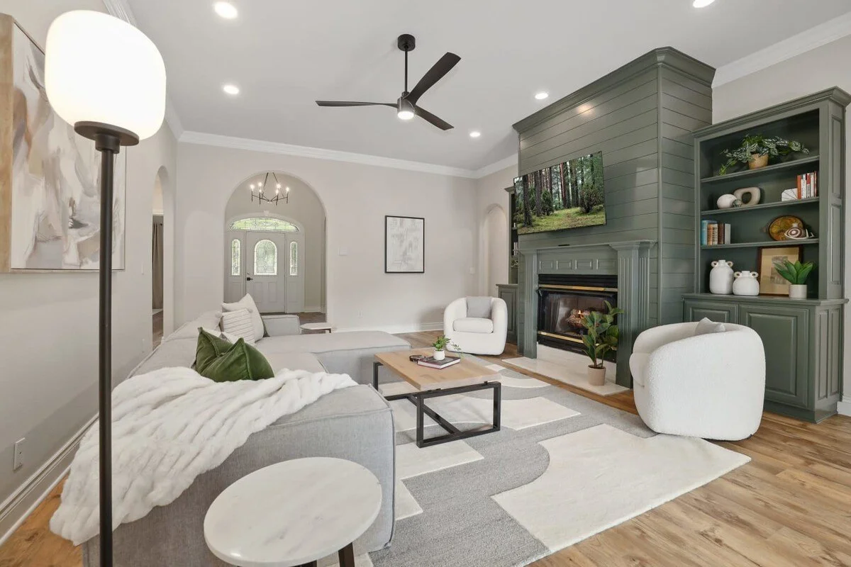 The living room is thoughtfully designed with a cozy plush sectional, lounge chairs, a 55-inch TCL Roku TV, a gas fireplace and gorgeous built-in shelves.