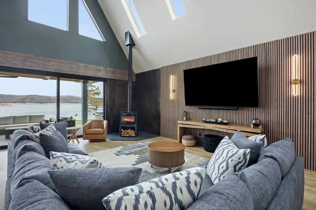 Open concept living space with high ceilings, cozy sectional, huge Smart TV, and electronic game tablet.