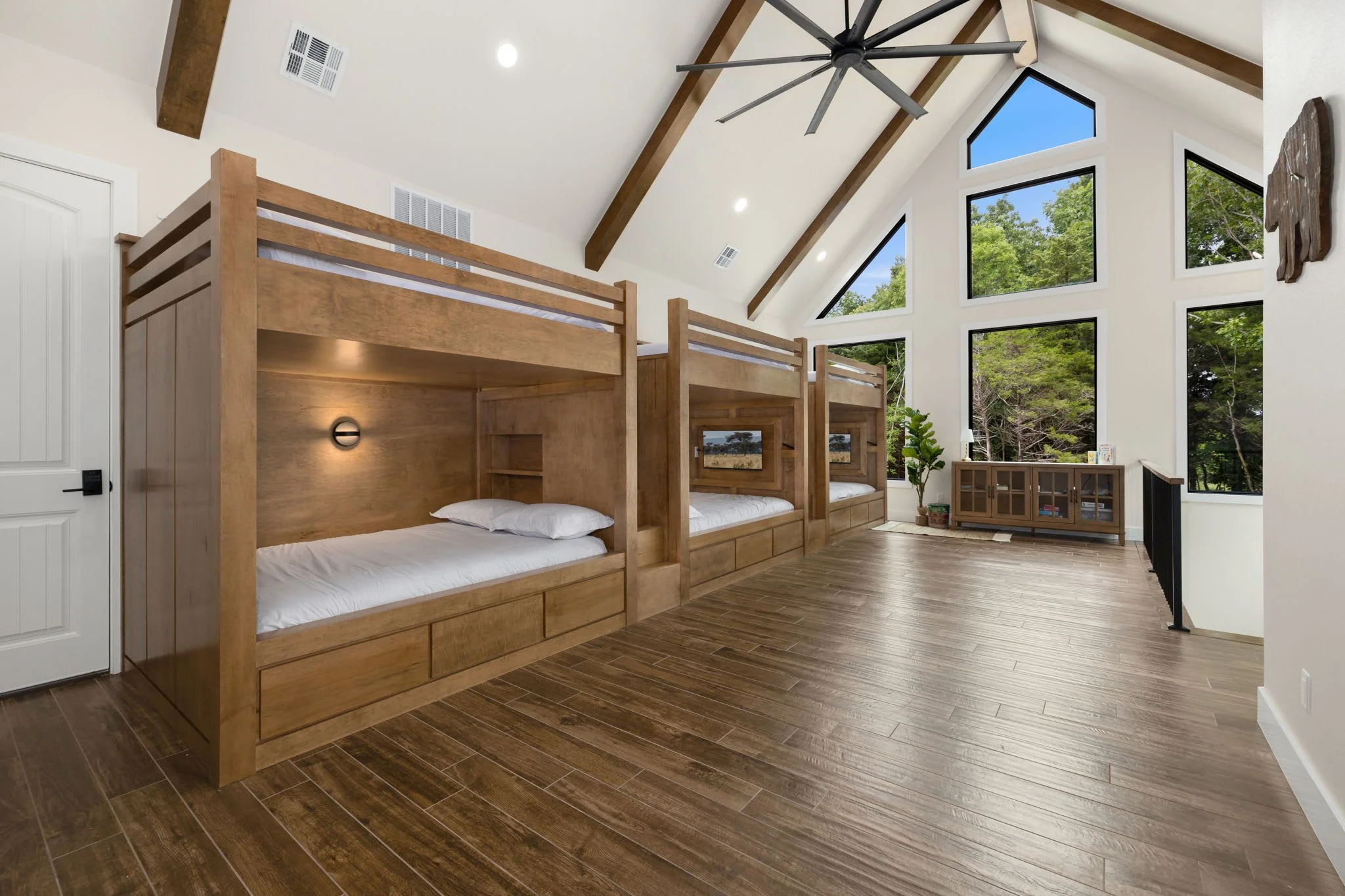 The upstairs loft has 3 Full/Full bunk beds built into the wall. All bottom bunks have a TV built right into them! This space is perfect for the kids! In total, Roaring River Hideaway has accommodations for 24 guests.