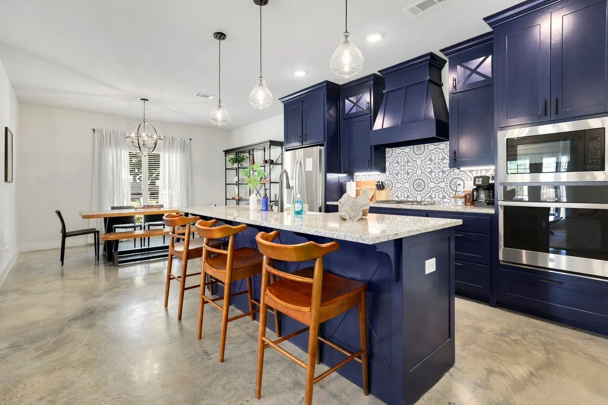 In the center of the open living space, enter our kitchen with a granite island and three barstools. The kitchen is fully stocked with all the cooking amenities you could ever need, including a drip coffee maker, a Keurig, high-end appliances and ple