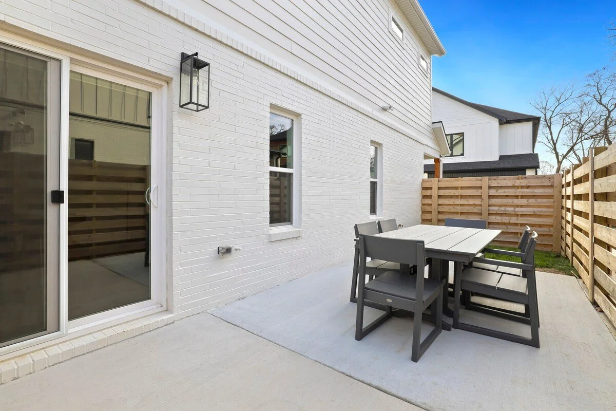 Through the sliding glass doors in our living room, you'll see our patio area. This space is fenced in and features a large outdoor dining table and a grill to take the party outside and getting some fresh air.