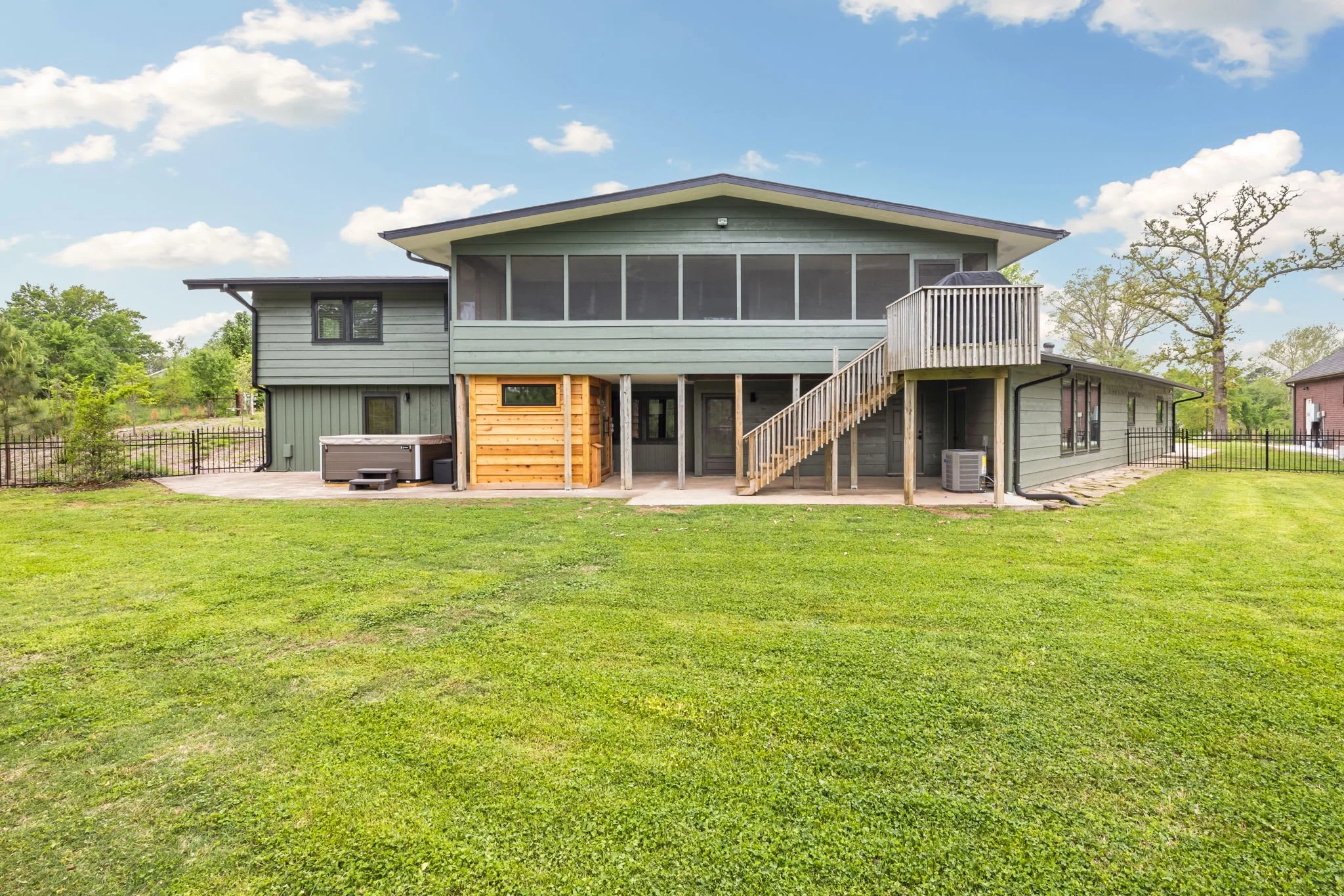 Walk out the enclosed patio onto the small deck with grill and step down to the fenced in backyard.