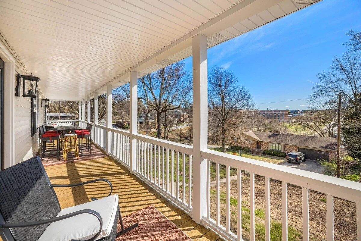 The upstairs balcony porch is complete with  a bar top table, rocking loveseat and outdoor sectional seating.