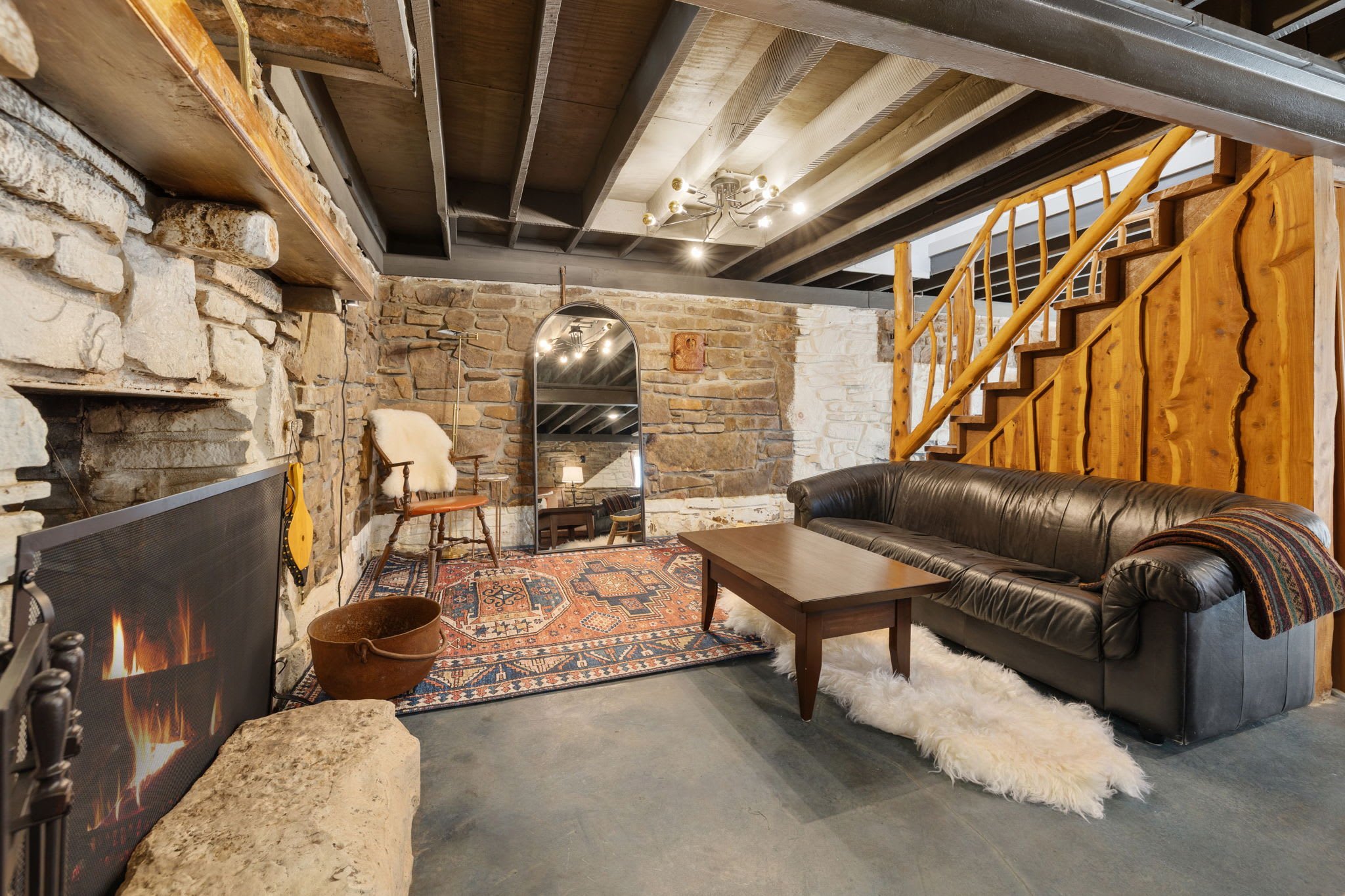 On the other side of the stairs, there is a second sofa and wood burning fireplace.